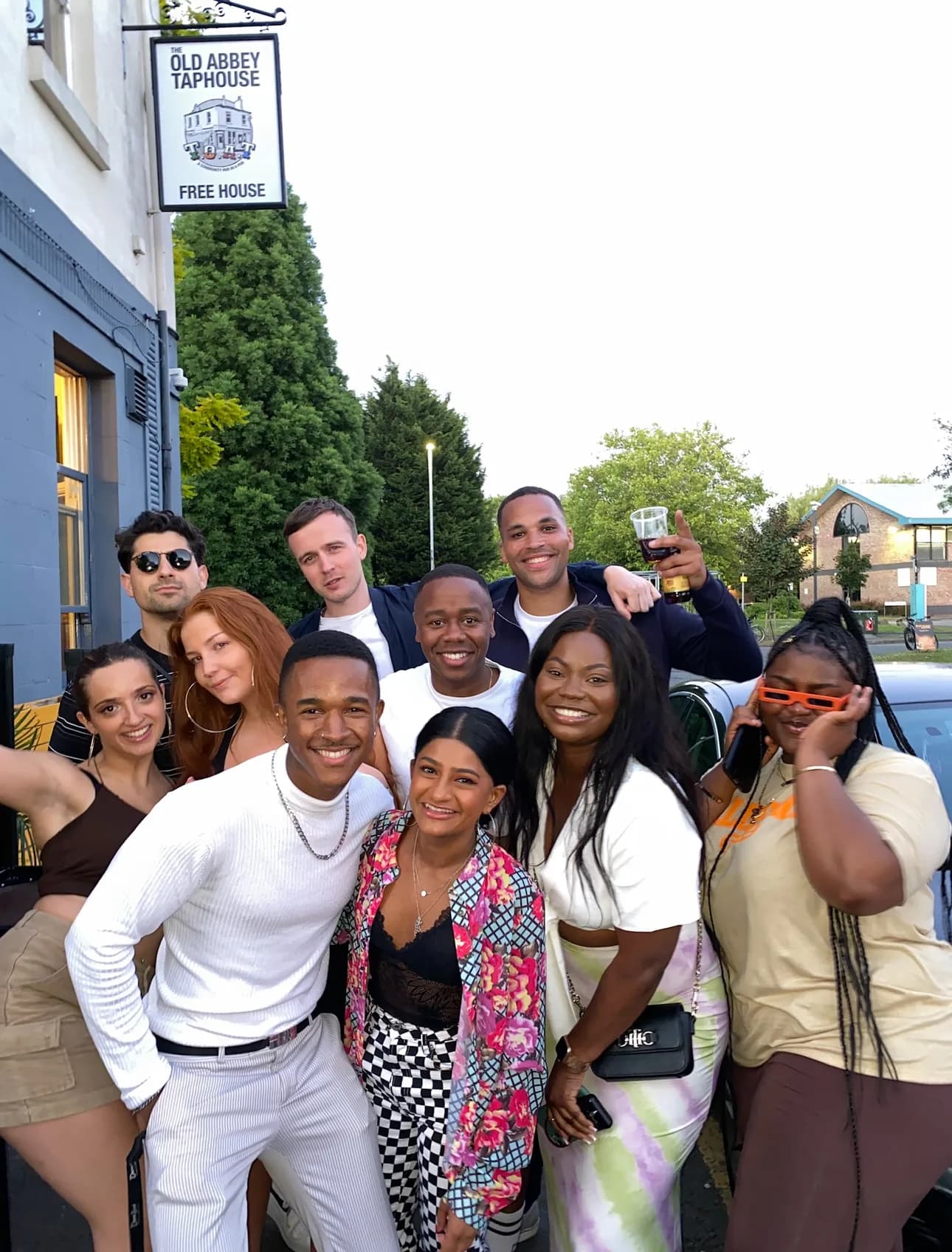 A group of friends pose together outside the Old Abbey Taphouse, under its Free House sign, at a Breaking Barz night