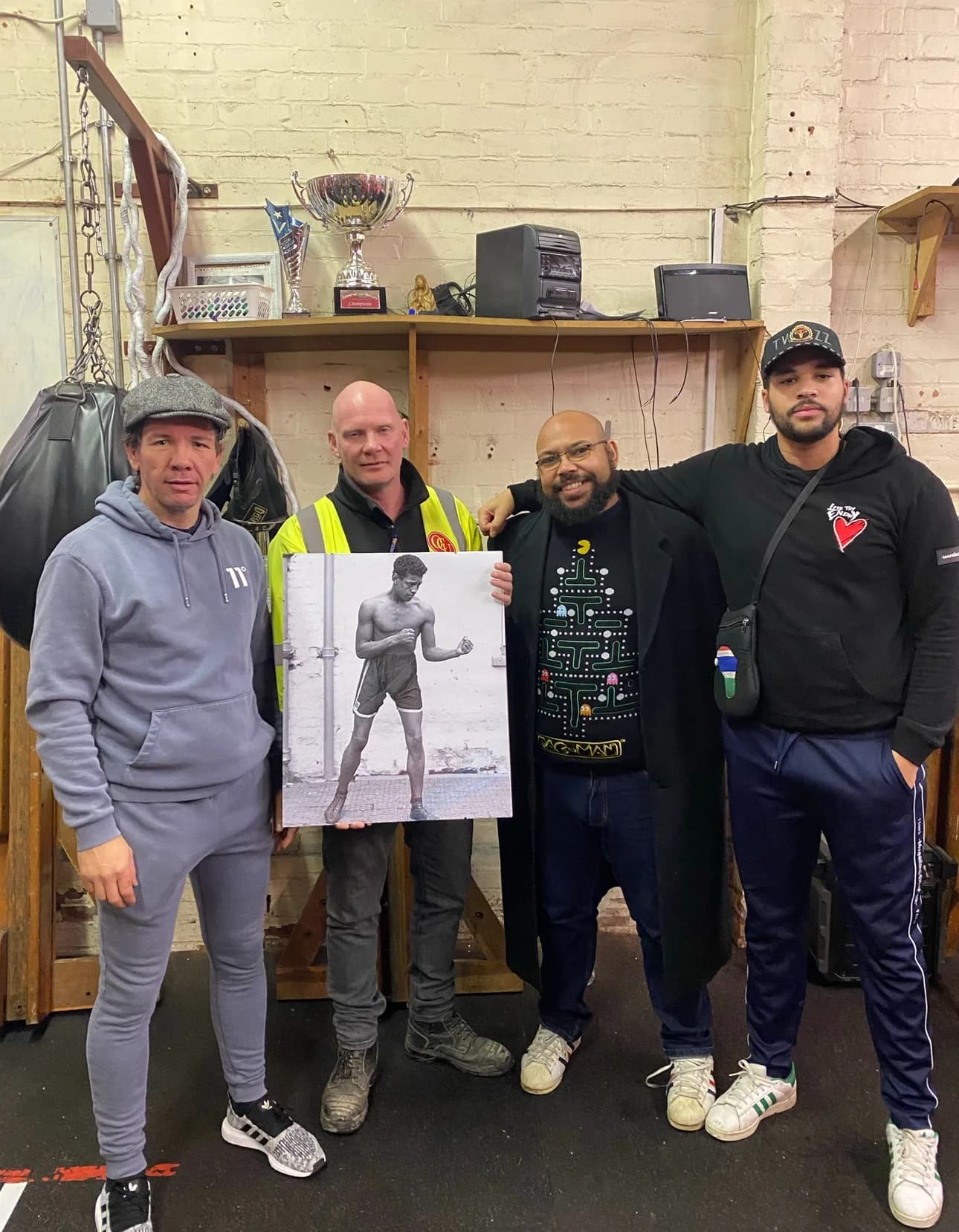 Campaign supporters at a boxing gym hold a canvas portrait of Len Johnson in his boxing stance