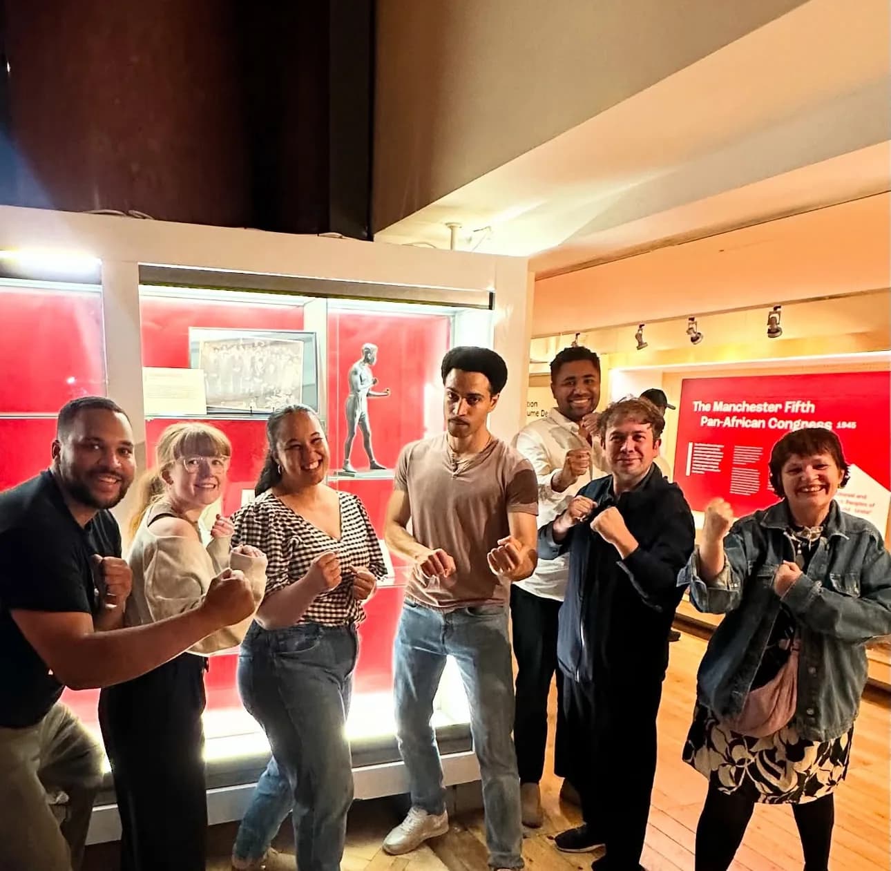 The cast and campaign visit a museum display on the Manchester Fifth Pan-African Congress of 1945, alongside a boxer statuette