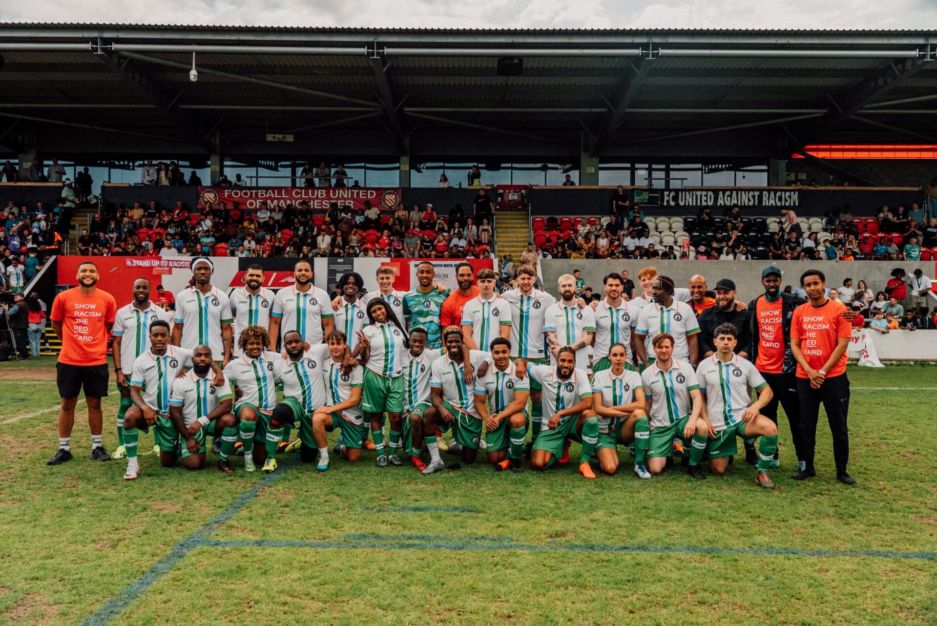 Players, staff and guests together on the pitch at Broadhurst Park after an FC United Legends v Len Johnson All Stars fundraising match