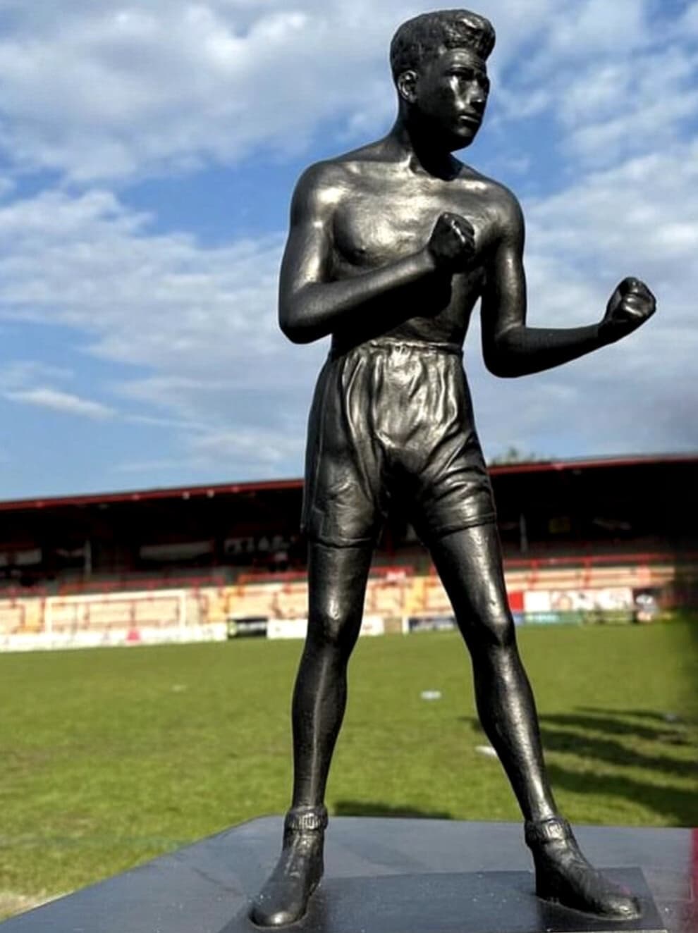 The Len Johnson maquette in a bronze finish, photographed pitchside at a football ground